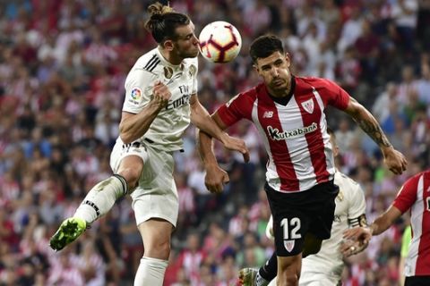Real Madrid 's Gareth Bale, duels for the ball with Athletic Bilbao's Yuri Berchiche during the Spanish La Liga soccer match between Athletic Bilbao and Real Madrid at San Mames stadium, in Bilbao, northern Spain, Saturday, Sept. 15, 2018.(AP Photo/Alvaro Barrientos)