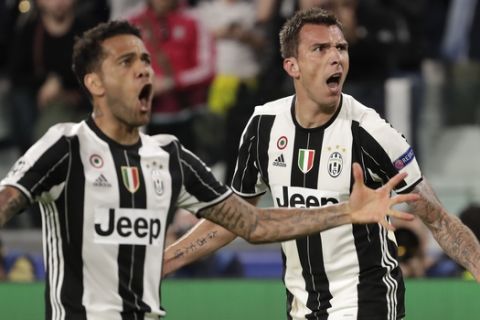 Juventus' Mario Mandzukic, right, celebrates after scoring his side's opening goal besides team mate Dani Alves during the Champions League semi final second leg soccer match between Juventus and Monaco in Turin, Italy, Tuesday, May 9, 2017. (AP Photo/Luca Bruno)