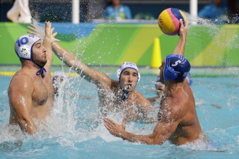 Greece's Ioannis Fountoulis, right, passes the ball forward as Serbia's Filip Filipovic, left, goes to block during their men's water polo preliminary round match at the 2016 Summer Olympics in Rio de Janeiro, Brazil, Monday, Aug. 8, 2016. (AP Photo/Sergei Grits)