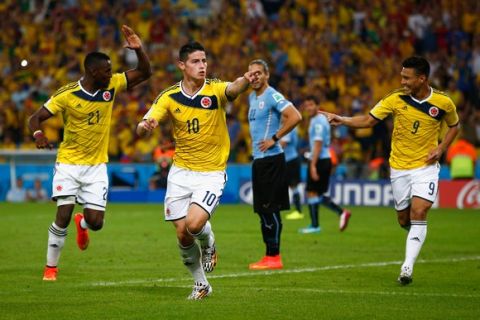 RIO DE JANEIRO, BRAZIL - JUNE 28: James Rodriguez of Colombia (C) celebrates scoring his team's second goal and his second of the game with teammates Jackson Martinez (L) and Teofilo Gutierrez during the 2014 FIFA World Cup Brazil round of 16 match between Colombia and Uruguay at Maracana on June 28, 2014 in Rio de Janeiro, Brazil.  (Photo by Clive Rose/Getty Images)