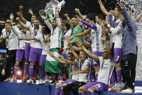 Real Madrid players celebrate holding the trophy after winning the Champions League soccer final between Juventus and Real Madrid at the Millennium Stadium in Cardiff, Wales, Saturday, June 3, 2017. (AP Photo/Kirsty Wigglesworth)
