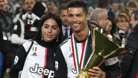 Juventus' Cristiano Ronaldo celebrates with his girlfriend Georgina, left, after winning the Serie A soccer title trophy, at the Allianz Stadium, in Turin, Italy, Sunday, May 19, 2019. (AP Photo/Antonio Calanni)