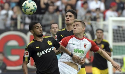Augsburg's Alfred Finnbogason, right, and Dortmund's Jeremy Toljan, left, and Marc Bartra vie for the ball during the German Bundesliga match between FC Augsburg and Borussia Dortmund in Augsburg, Germany, Saturday, Sept. 30, 2017. (Stefan Puchner/dpa via AP)
