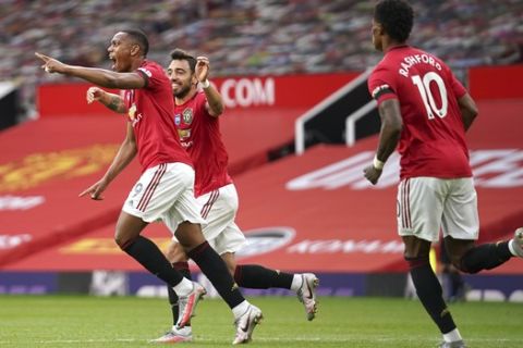 Manchester United's Anthony Martial, left, celebrates after scoring his ream's second goal during the English Premier League soccer match between Manchester United and Southampton at Old Trafford in Manchester, England, Monday, July 13, 2020. (AP Photo/Dave Thompson,Pool)