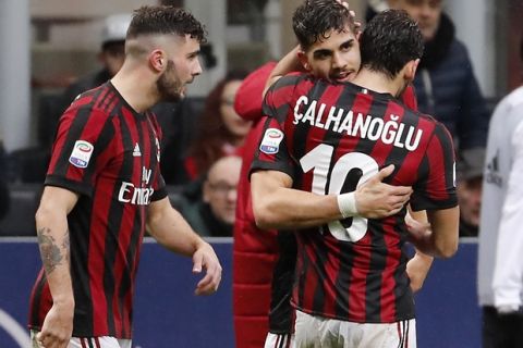 AC Milan's Andre Silva, center, celebrates with his teammates Patrick Cutrone , left, and Hakan Calhanoglu after scoring his side's third goal during the Serie A soccer match between AC Milan and Chievo Verona at the San Siro stadium in Milan, Italy, Sunday, March 18, 2018. (AP Photo/Antonio Calanni)