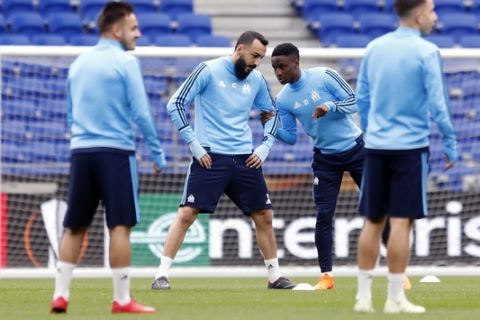 Olympique Marseille's Konstantínos Mítroglou, centre left, speaks with Bouna Sarr, as they train at the Groupama stadium in Decines, outside Lyon, central France, Tuesday, May 15, 2018. Marseille will play Atletico Madrid in the Europa League final on Wednesday. (AP Photo/Laurent Cipriani)