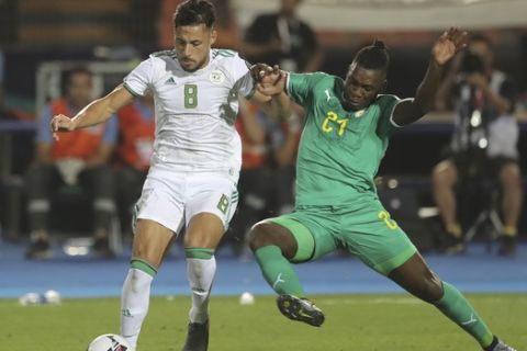 Algeria's Mohamed Belaili, left, andSenegal's Lamine Gassama fight for the ball during the African Cup of Nations final soccer match between Algeria and Senegal in Cairo International stadium in Cairo, Egypt, Friday, July 19, 2019. (AP Photo/Amr Nabil)
