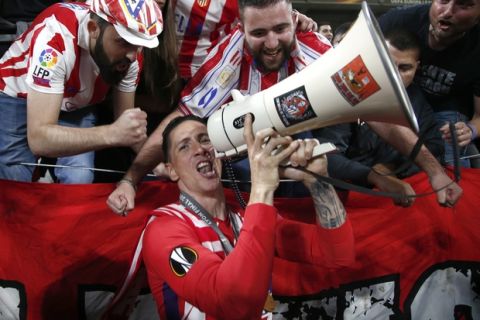Surrounded by fans Atletico's Fernando Torres celebrates the 3-0 win of his team after the Europa League Final soccer match between Marseille and Atletico Madrid at the Stade de Lyon in Decines, outside Lyon, France, Wednesday, May 16, 2018. (AP Photo/Thibault Camus)