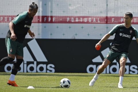 Portugal's Cristiano Ronaldo, right, plays the ball with teammate Bruno Alves during the training session of Portugal at the 2018 soccer World Cup in Kratovo, outskirts Moscow, Russia, Sunday, June 17, 2018. (AP Photo/Francisco Seco)