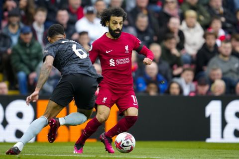 Liverpool's Mohamed Salah, right, duels for the ball with Arsenal's Gabriel during the English Premier League soccer match between Liverpool and Arsenal at Anfield in Liverpool, England, Sunday, April 9, 2023. (AP Photo/Jon Super)