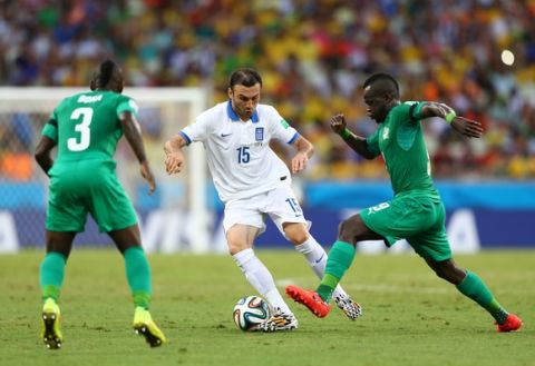FORTALEZA, BRAZIL - JUNE 24: Vasilis Torosidis of Greece is challenged by Arthur Boka (L) and Cheick Tiote of the Ivory Coast during the 2014 FIFA World Cup Brazil Group C match between Greece and the Ivory Coast at Castelao on June 24, 2014 in Fortaleza, Brazil.  (Photo by Michael Steele/Getty Images)