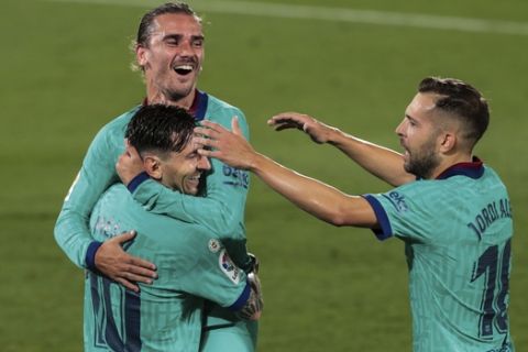 Barcelona's Antoine Griezmann, top, is congratulated by teammate Lionel Messi, left, and Jordi Alba, right, after scoring his side third goal during the Spanish La Liga soccer match between FC Barcelona and Villareal at La Ceramica stadium in Villareal, Spain, Sunday, July 5, 2020. (AP Photo/Jose Miguel Fernandez)