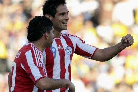 Paraguay's Roque Santa Cruz (R) celebrates with team mate Nestor Ortigaza after scoring during their match against Brazil in the first round of the Copa America soccer tournament in Cordoba, July 9, 2011.   REUTERS/Andres Stapff (ARGENTINA - Tags: SPORT SOCCER)