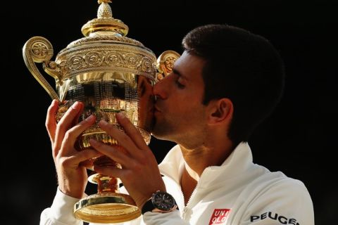 LONDON, ENGLAND - JULY 06:  Novak Djokovic of Serbia kisses the Gentlemen's Singles Trophy following his victory in the Gentlemen's Singles Final match against Roger Federer of Switzerland on day thirteen of the Wimbledon Lawn Tennis Championships at the All England Lawn Tennis and Croquet Club on July 6, 2014 in London, England.  (Photo by Matthew Stockman/Getty Images)