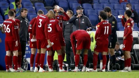 Liverpool's manager Jurgen Klopp talks with his players during a break in the English Premier League soccer match between Brighton and Liverpool at Falmer Stadium in Brighton, England, Wednesday, July 8, 2020. (AP Photo/Paul Childs,Pool)