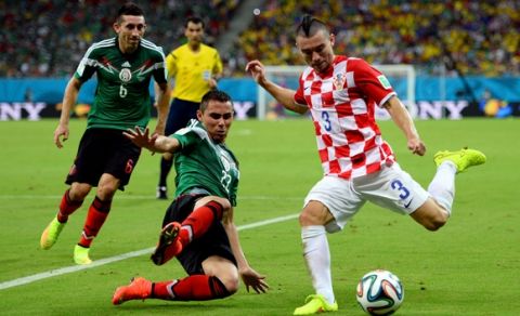 RECIFE, BRAZIL - JUNE 23:  Danijel Pranjic of Croatia controls the ball as Paul Aguilar of Mexico gives chase during the 2014 FIFA World Cup Brazil Group A match between Croatia and Mexico at Arena Pernambuco on June 23, 2014 in Recife, Brazil.  (Photo by Jamie McDonald/Getty Images)