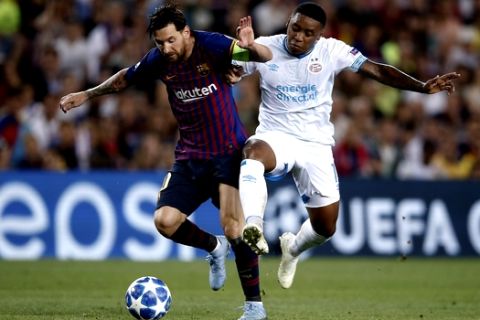 PSV's Steven Bergwijn, right, tries to stop Barcelona forward Lionel Messi during the group B Champions League soccer match between FC Barcelona and PSV Eindhoven at the Camp Nou stadium in Barcelona, Spain, Tuesday, Sept. 18, 2018. (AP Photo/Manu Fernandez)