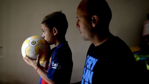In this Jan. 25, 2017 photo, young soccer player Benjamin Palandella stands with his father Gaston at their home in Buenos Aires, Argentina. "Benjamin is very shy, but he transforms himself on the field," his father said. (AP Photo/Natacha Pisarenko)