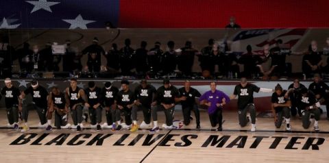 The Los Angeles Lakers and the Los Angeles Clippers wear Black Lives Matter shirts and kneel during the national anthem prior to an NBA basketball game Thursday, July 30, 2020, in Lake Buena Vista, Fla. (Mike Ehrmann/Pool Photo via AP)