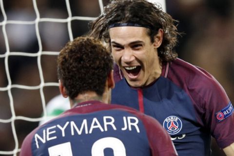 PSG's Edinson Cavani, right, celebrates after scoring his side's third goal with his teammate Neymar during a Champions League Group B soccer match between Paris St. Germain and Celtic at the Parc des Princes stadium in Paris, France, Wednesday, Nov. 22, 2017. Banner in the middle reads : Never alone. (AP Photo/Christophe Ena)