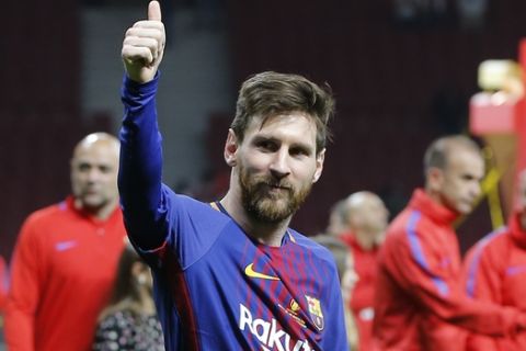 Barcelona's Lionel Messi celebrates during an award ceremony after defeating Sevilla 5-0 in the Copa del Rey final soccer match at the Wanda Metropolitano stadium in Madrid, Spain, Saturday, April 21, 2018. (AP Photo/Paul White)