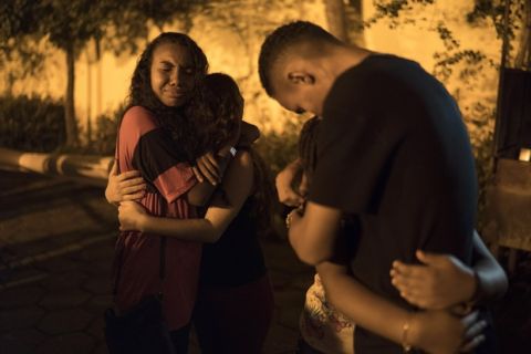 Friends embrace outside a church after attending a memorial Mass for the victims of a fire at a Brazilian soccer academy, in Rio de Janeiro, Brazil, Friday, Feb. 8, 2019. A fire early Friday swept through the sleeping quarters of an academy for Brazil's popular professional soccer club Flamengo, killing 10 people and injuring three, most likely teenage players, authorities said. (AP Photo/Leo Correa)