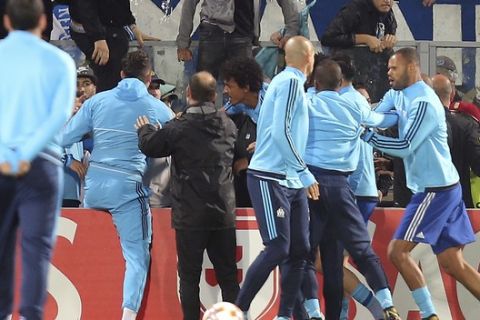 Marseille players, foreground, get involved in a scuffle with Marseille supporters who trespassed into the field before the Europa League group I soccer match between Vitoria SC and Olympique de Marseille at the D. Afonso Henriques stadium in Guimaraes, Portugal, Thursday, Nov. 2, 2017. (AP Photo/Luis Vieira)