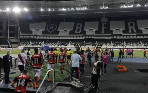 Players of Brazil's Flamengo, right, and Argentina's River Plate enter the field to play a Copa Libertadores soccer match with an empty stadium in Rio de Janeiro, Brazil, Wednesday, Feb. 28, 2018. The South American football federation has ordered Flamengo to play two matches in an empty stadium as punishment for the bad behavior of their fans during the Copa Sudamericana final match against Argentina's Independent last year. (AP Photo/Leo Correa)