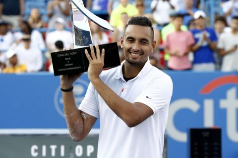 Nick Kyrgios, of Australia, poses for photos with a trophy after defeating Daniil Medvedev, of Russia, in a final match at the Citi Open tennis tournament, Sunday, Aug. 4, 2019, in Washington. (AP Photo/Patrick Semansky)