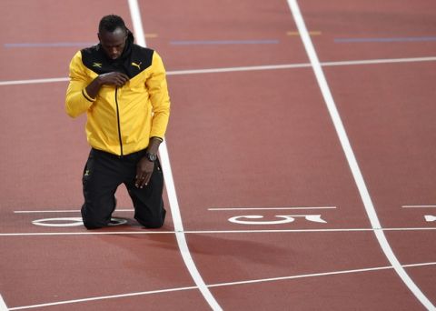 Jamaica's Usain Bolt kneels on the finish line during a farewell lap during the World Athletics Championships in London Sunday, Aug. 13, 2017. (AP Photo/Martin Meissner)