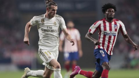 Real Madrid's Gareth Bale and Atletico Madrid's Thomas Partey, right, vie for the ball during the Spanish La Liga soccer match between Atletico Madrid and Real Madrid at the Wanda Metropolitano stadium in Madrid, Saturday, Sept. 28, 2019. (AP Photo/Bernat Armangue)
