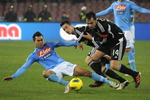 Napoli forward Eduardo Vargas of Chile, left, is fouled by two Cesena's defenders during a Cup of Italy soccer match at the San Paolo stadium in Naples, Italy, Thursday, Dec. 12, 2012. (AP Photo/Salvatore Laporta)