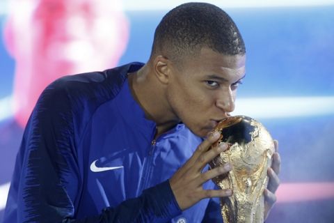 Kylian Mbappe of France kisses the World Cup trophy during a ceremony to celebrate France's victory in the FIFA 2018 World Cup, following the UEFA Nations League soccer match between France and the Netherlands at the Stade De France in Paris, Sunday, Sept. 9, 2018. (AP Photo/Thibault Camus)