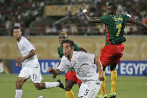 USA's Danny Cruz, center, recovers from a header by Cameroon's Olivier Boumale, right, during the USA vs Cameroon U-20 World Cup group C soccer match at the Mubarak stadium in Suez, Egypt, Tuesday, Sept. 29, 2009. (AP Photo/Ben Curtis)