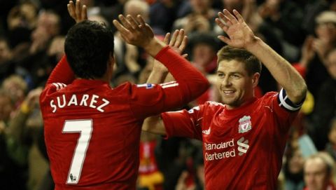 Liverpool's Steven Gerrard, right, celebrates with teammate Luis Suarez after Brighton and Hove Albion scored an own goal during their English FA Cup fifth round soccer match at Anfield, Liverpool, England, Sunday Feb. 19, 2012. (AP Photo/Tim Hales)