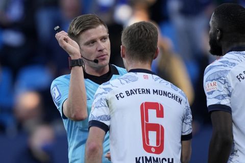 Referee Robert Schroeder talks with Bayern's Joshua Kimmich after a penalty decision during the German Bundesliga soccer match between VfL Bochum and Bayern Munich in Bochum, Germany, Saturday, Feb. 12, 2022. (AP Photo/Martin Meissner)