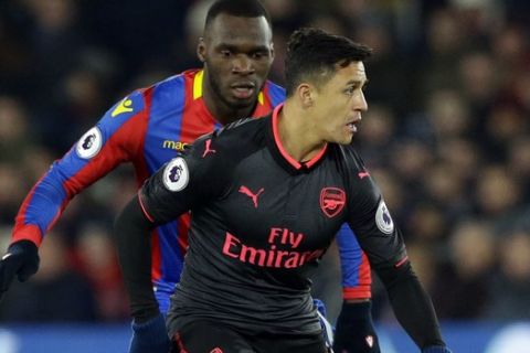 Arsenal's Alexis Sanchez, front, shields the ball from Crystal Palace's Christian Benteke during their English Premier League soccer match between Crystal Palace and Arsenal at Selhurst Park stadium in London, Thursday, Dec. 28, 2017. (AP Photo/Alastair Grant)
