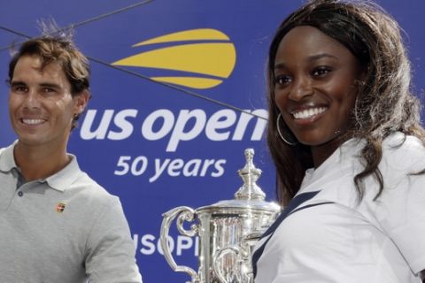 Defending champions Rafael Nadal and Sloane Stevens pose with the tournament's trophies during the reveal of the 2018 U.S. Open draw in New York, Thursday, Aug. 23, 2018.  (AP Photo/Richard Drew)