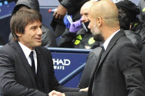 Chelsea manager Antonio Conte, left, shakes hands with Manchester City manager Josep Guardiola during the English Premier League soccer match between Manchester City and Chelsea at the Etihad Stadium in Manchester, England, Saturday, Dec. 3, 2016. (AP Photo/Rui Vieira)