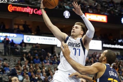 Dallas Mavericks forward Luka Doncic (77) makes a layup in front of Utah Jazz guard Ricky Rubio (3) and center Rudy Gobert (27) during the first half of an NBA basketball game in Dallas, Wednesday, Nov. 14, 2018. (AP Photo/Michael Ainsworth)