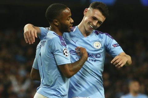Manchester City's Raheem Sterling, left, celebrates with his teammate Phil Foden after scoring his side's fourth goal, during the group C Champions League soccer match between Manchester City and Atalanta at the Etihad Stadium in Manchester, England, Tuesday, Oct. 22, 2019. (AP Photo/Dave Thompson)