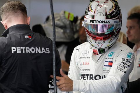 Mercedes driver Lewis Hamilton, of Britain, walks past a crew member during the first practice session for the Formula One U.S. Grand Prix auto race at the Circuit of the Americas, Friday, Oct. 19, 2018, in Austin, Texas. (AP Photo/Darron Cummings)