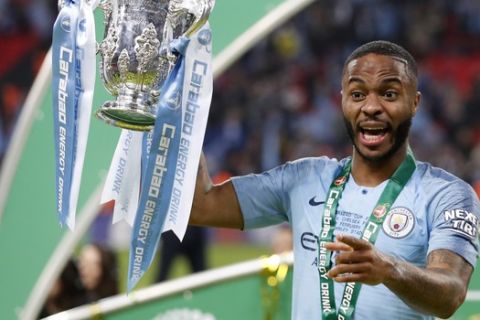 Manchester City's Raheem Sterling celebrates with trophy after winning the English League Cup final soccer match between Chelsea and Manchester City at Wembley stadium in London, England, Sunday, Feb. 24, 2019. (AP Photo/Alastair Grant)