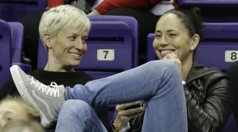 Seattle Reign's Megan Rapinoe, left, and Seattle Storm's Sue Bird chat as they look on at an NCAA college basketball game between Washington and Boise State Sunday, Dec. 11, 2016, in Seattle. Washington won 92-66. (AP Photo/Elaine Thompson)