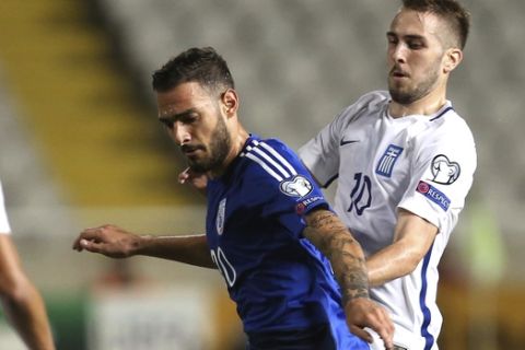 Cyprus' Grigoris Kastanos, left, battles for the ball with Greece's Kostas Fortounis during their World Cup Group H qualifying soccer match between Cyprus and Greece at GSP stadium in Nicosia, Cyprus, Saturday, Oct. 7, 2017. (AP Photo/Petros Karadjias)