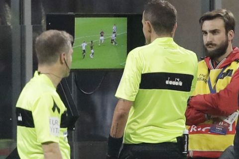 Referee Paolo Silvio Mazzoleni, center checks the VAR during a Serie A soccer match between AC Milan and Juventus, at Milan's San Siro stadium, Sunday, Nov. 11, 2018. (AP Photo/Luca Bruno)