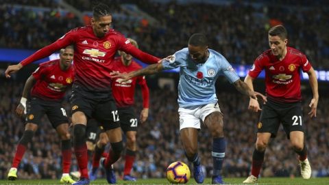 Manchester United's Chris Smalling, left, Manchester United's Ander Herrera, right, and Manchester City's Rahhem Sterling challenge for the ball during the English Premier League soccer match between Manchester City and Manchester United at the Etihad stadium in Manchester, England, Sunday, Nov. 11, 2018. (AP Photo/Dave Thompson)