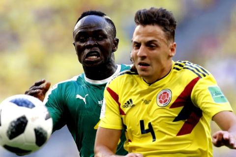 Colombia's Santiago Arias, foreground, and Senegal's Sadio Mane challenge for the ball during the group H match between Senegal and Colombia, at the 2018 soccer World Cup in the Samara Arena in Samara, Russia, Thursday, June 28, 2018. (AP Photo/Efrem Lukatsky)