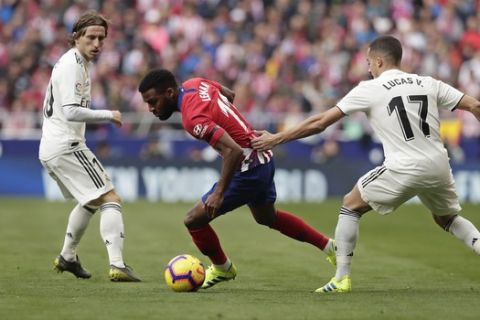 Atletico Madrid's Thomas Lemar, centre, takes the ball past Real Madrid's Lucas Vazquez, right, during a Spanish La Liga soccer match between Atletico Madrid and Real Madrid at the Metropolitano stadium in Madrid, Spain, Saturday, Feb. 9, 2019. (AP Photo/Manu Fernandez)