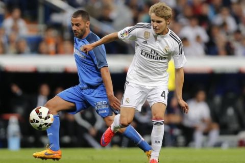 Real Madrid's Martin Odegaard from Norway, right, duels for the ball with Getafe's Lacen, during a Spanish La Liga soccer match between Real Madrid and Getafe at the Santiago Bernabeu stadium in Madrid, Spain, Saturday, May 23, 2015. (AP Photo/Daniel Ochoa de Olza)